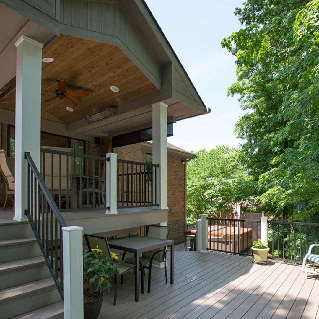 A multi-level outdoor wooden deck with a covered dining area and a lower patio with a hot tub.