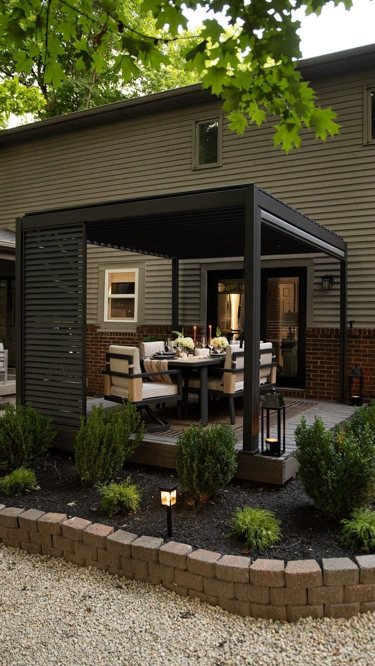 A black louvered pergola sheltering a dining set with cream cushions on a patio.